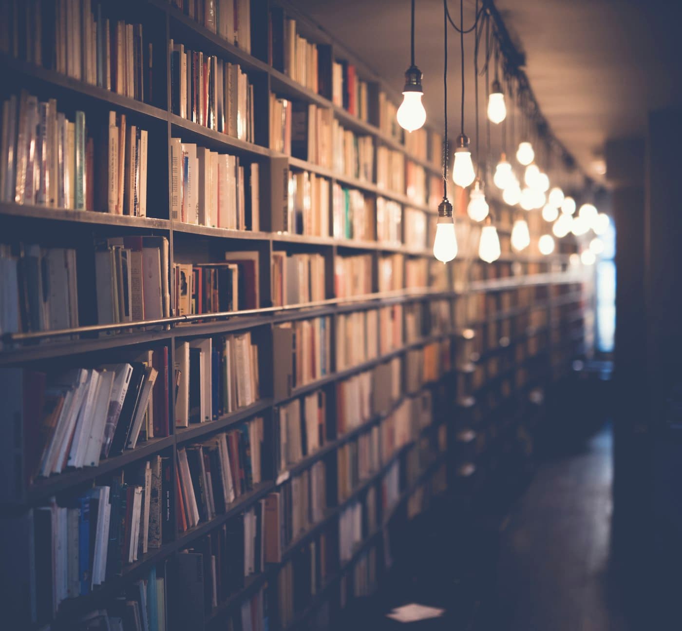 Long rows of bookshelves in a warmly lit library