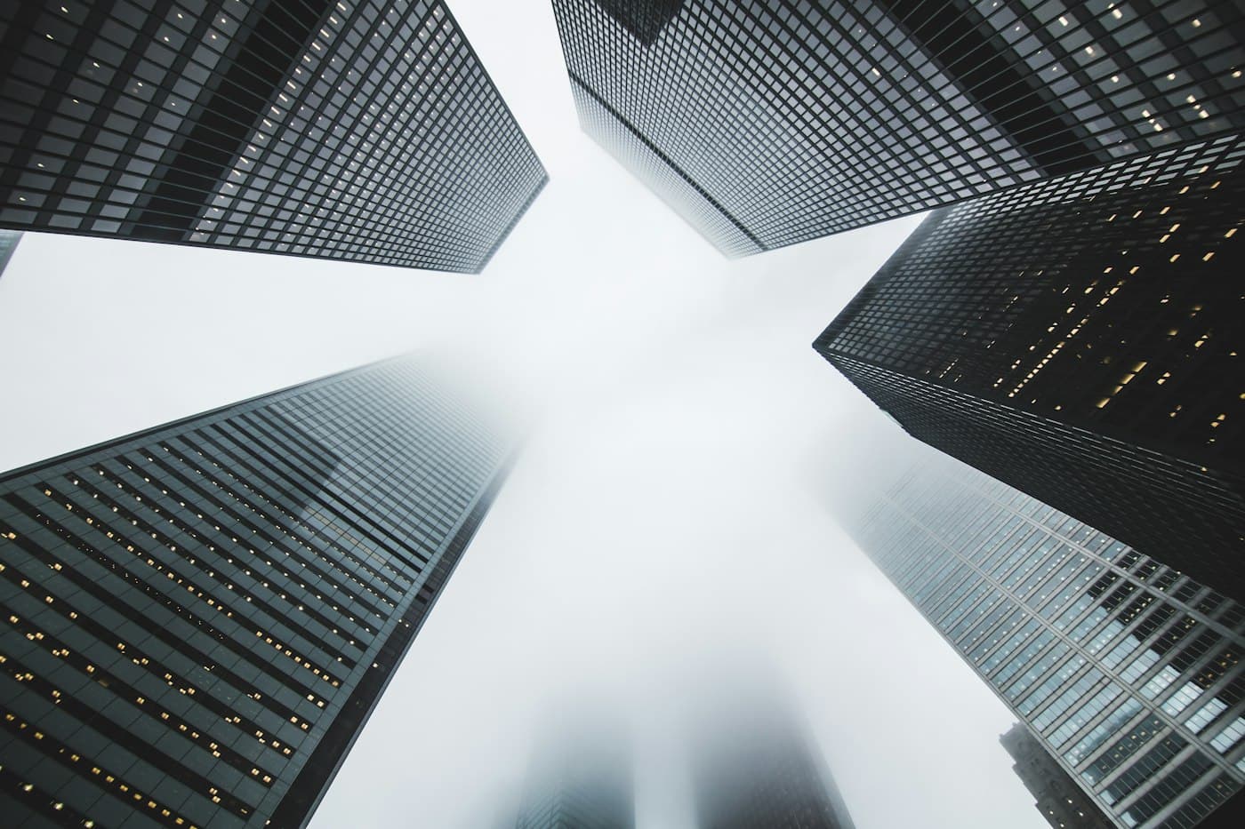 Dark glass office towers converging toward the sky